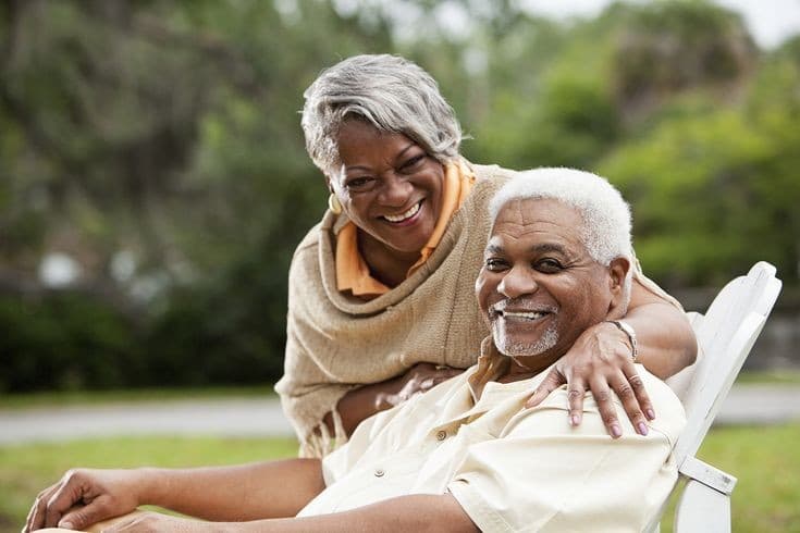 Caretaker helping a smiling senior woman at home